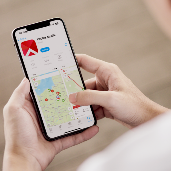 mężczyzna trzymający telefon w ręku z włączoną aplikacją TRONIK Mobile